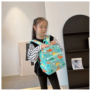 Kids blue backpack featuring colorful cartoon dinosaur patterns worn by a child