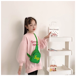 Close-up of kids green canvas chest bag with yellow lettering on pink sweatshirt