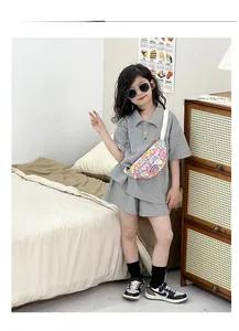 Detailansicht eines Kindes mit bunter Cartoon-Gürteltasche und grauem Polo-Outfit