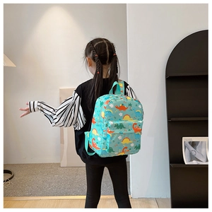 Toddler backpack with colorful dinosaur print on light green fabric showing back view