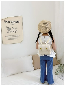 Detailed view of kids cream PU leather backpack featuring retro gold buckles and straps