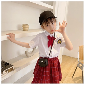 Close-up of girls academy style uniform set with white shirt and red plaid pleated skirt