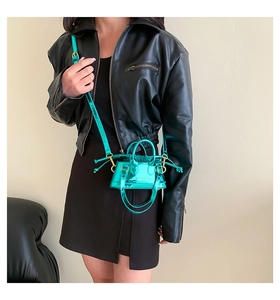 Close-up of a mini neon green patent leather shell bag with metallic glossy finish