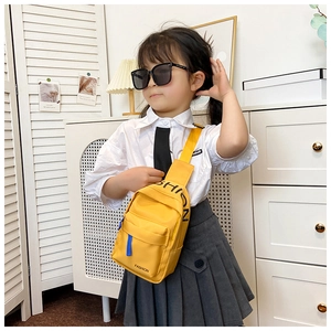 Detail of yellow nylon kids chest bag with FASHION lettering and blue accents