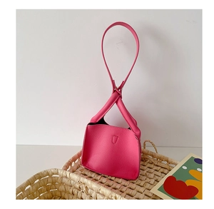 Detailed texture of rose pink lychee leather handbag with a unique round top handle