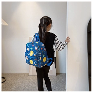 Detailed view of the cartoon space pattern and waterproof nylon fabric on kids backpack