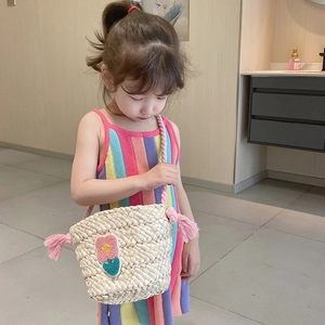 Girl's handmade straw crossbody bag with pink tassel and colorful floral patch