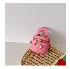 Détail du mini sac seau rose montrant les zips à boules dorées et la bandoulière