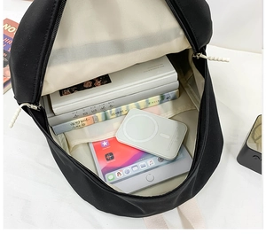 Vue détaillée de l'intérieur du sac à dos en toile noire montrant la grande capacité de rangement