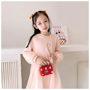 Détail du mini sac en silicone rose avec anse en perles et fleurs sur tenue d'enfant