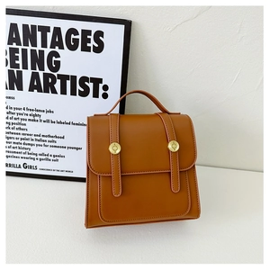 Detail of caramel brown PU leather backpack with vintage golden circular hardware buckles