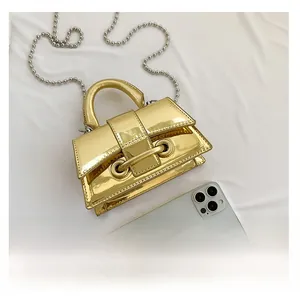 Detailed comparison of the mini gold metallic handbag next to a smartphone for size reference