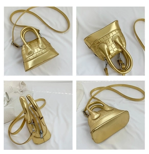 Detail view of mini shell bag in metallic gold finish with crocodile pattern texture