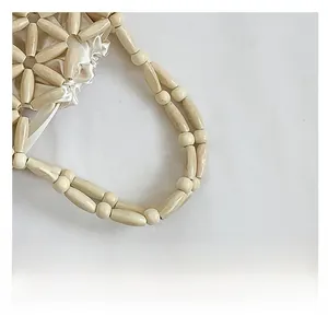 Detailed close-up of cream beaded handbag handle with elegant white satin lining detail