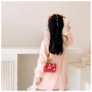 Détail du sac enfant en silicone rouge matelassé avec breloques cartoon et anse perle