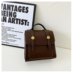 Detail of vintage coffee brown PU leather kids backpack with golden circular rotary lock