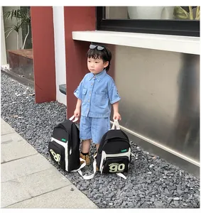 Vue détaillée du sac à dos enfant noir et blanc avec imprimé sportif du numéro 90