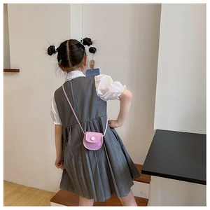 Mini purple PU leather crossbody bag for girls showing back and side view on child model