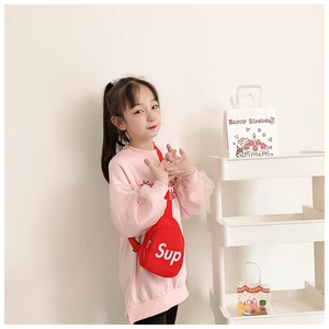 Close-up of child canvas chest bag with white letter print and pink mesh sleeve detail