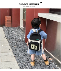 Sac à dos sport enfant noir et blanc avec imprimé basketball porté par un modèle