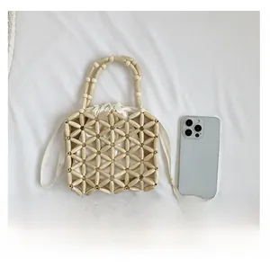 Detail of hand-beaded straw-style bag with floral patterns and internal satin pouch