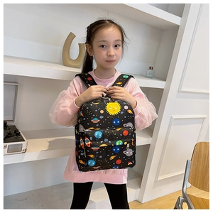 Front view of a young girl wearing a lightweight cosmic space print kids backpack