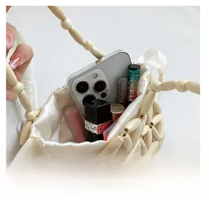 Detail view of woven beaded handbag interior with drawstring satin lining and storage space