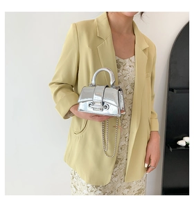 Close-up of silver mirror mini handbag with metal beads chain and grommet details