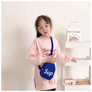 Detail of child wearing a navy blue canvas crossbody chest bag with white letter print