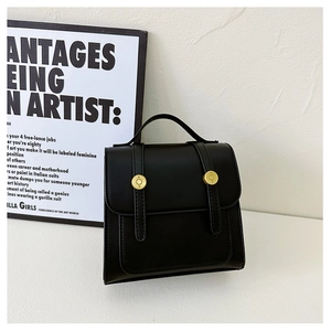 Detailed view of black PU leather backpack with vintage buckles and school style