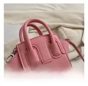 Dettaglio mini borsa a conchiglia rosa con manico robusto e fibbie metalliche decorative