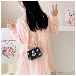 Vue arrière d'une fille en robe rose portant un sac en silicone noir matelassé avec perles