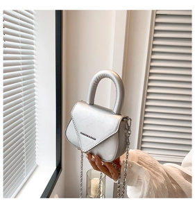 Details einer silbernen Metallic-Mini-Handtasche mit eleganter Kette und V-Klappe