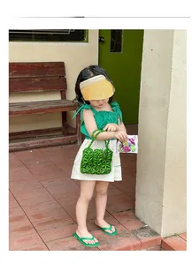 Detail display of a green beaded flower handbag for girls with a summer fashion outfit