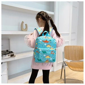 Toddler wearing a sky blue backpack with colorful dinosaur prints in a bright room