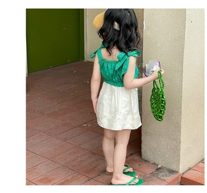 Close-up of a handmade green beaded handbag for girls styled with a summer dress