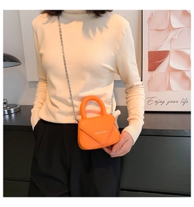 Detail der orangefarbenen Mini-Umhängetasche aus PU-Leder mit silberner Kette