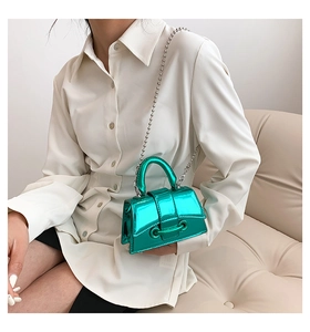 Detail of a shiny metallic lake green mini handbag with a silver beaded chain strap