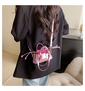 Close-up of a mini shiny pink patent leather shell bag with satin drawstring liner