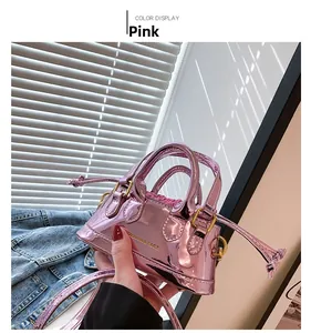 Detailed view of mini pink patent leather shell bag with adjustable shoulder strap