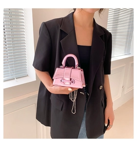 Detail of metallic pink mini bag with silver bead chain and glossy mirror finish
