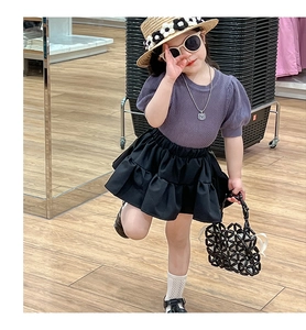 Girl's summer outfit featuring purple knit top, black tiered skirt and beaded handbag