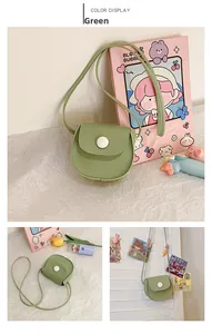 Detail of green PU leather mini crossbody bag with large white button and flap closure