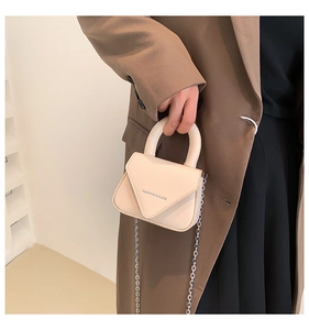 Detail der minimalistischen cremefarbenen Minitasche mit silberner Kette und Klappe