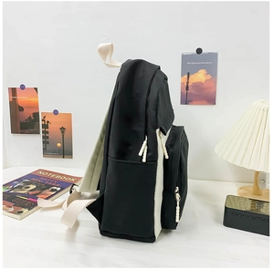 Vue latérale du sac à dos en toile noir et blanc avec poche latérale et fermeture éclair