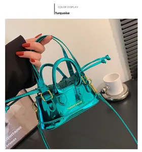 Close-up of metallic green mini shell bag with gold lettering and drawstring detail