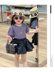 Kids purple puff sleeve top and black layered tutu skirt outfit shown on a model