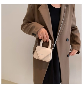 Details einer cremefarbenen Mini-Umhängetasche mit Silberkette und FASHION & BAGS-Logo