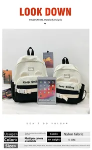 Size comparison of nylon canvas school backpacks using a tablet for scale reference