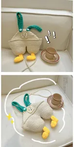 Detail of handmade crochet overall-style crossbody bag with pearl chain and duck feet charms